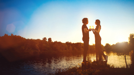 Romantic couple with the candles on the sunset background.の写真素材