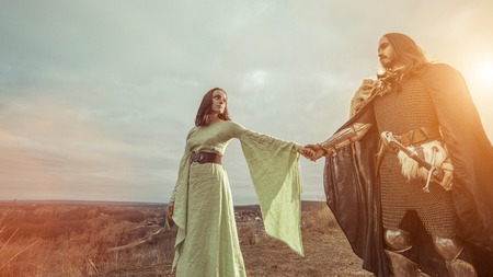 Medieval knight with lady on the sunset background.の写真素材