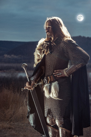 Long haired knight with the two-handed sword. Moon on the background.の写真素材