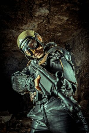 Beautiful woman soldier in leather clothing with the gun