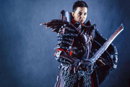 Portrait of a medieval female knight in armour over blue background.