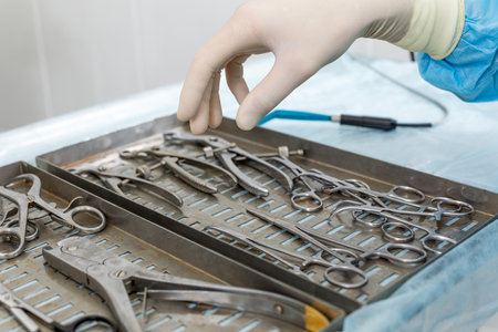 Detail shot of steralized surgery instruments with a hand grabbing a toolの写真素材