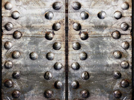 Several old rusty metal plates with rivets