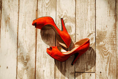 Women's shoes bright red suede on the wooden background.Women's shoes bright red suede on a wooden background.の写真素材