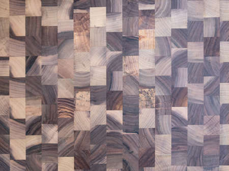 Background. Checkered wooden board made of medium-sized squares of different types of wood.