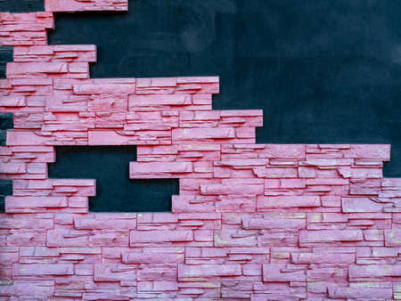 On a dark blue wall, a mosaic of pink bricks. Decorative brick wall texture. Copy space.の写真素材