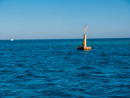 Iron buoy on the blue sea. A buoy is a floating device that guides the boats on a safe path.の写真素材