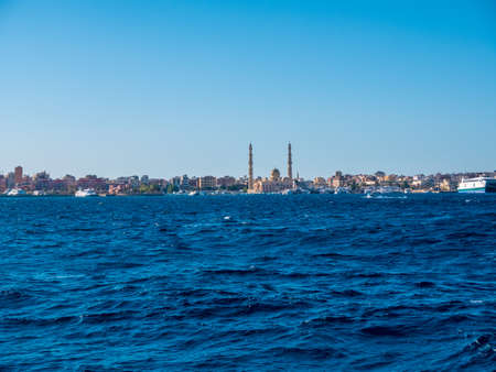 Wonderful view of the mosque with two minarets on the seashore against the backdrop of sea waves.の写真素材