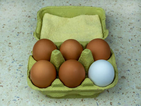 Six natural eggs in a green cardboard box. View from above. Copy space.