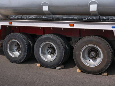 Close-up of three big black wheels on a truck trailer.