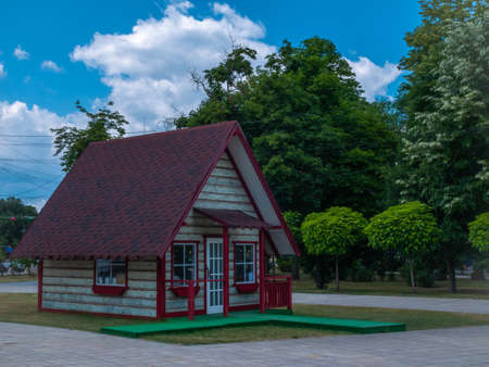 A small traditional country house with a flower bed, a green grassy path and a garden.の写真素材