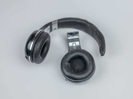 Broken headphones isolated on a light background. Close-up, top view. The concept of non-recyclable electronics waste. Flat layの写真素材