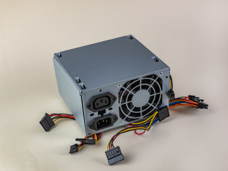 Computer power supply with wires close-up on a light background. Old dead computer power supply with different wires and connections. Computer repair workshop conceptの写真素材