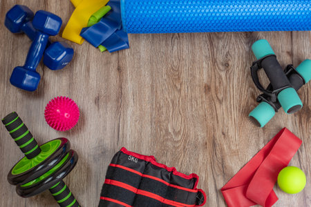 Sports and training equipment for fitness and physical education. Dumbbells, fitness roller, spiky and smooth acupuncture balls, ab and back roller, elastic bands. Concept of active lifestyleの写真素材