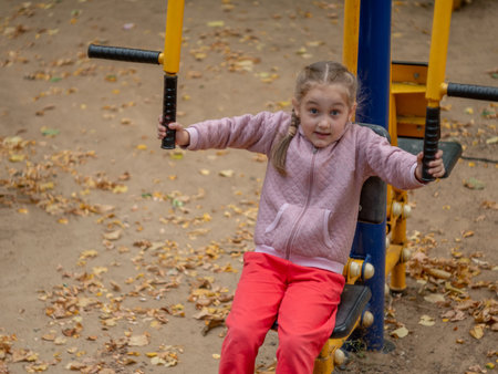Sports ground. A 7-8 year old girl is engaged in a sports simulator.の写真素材
