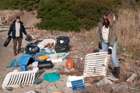 Clearing up rubbish washed up onto a small beachのeditorial素材