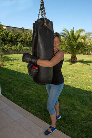 Young female boxing using a punch bagの写真素材