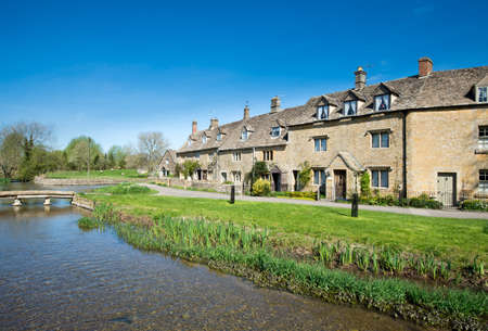Cottages by a stream in the Cotswold village of Lower Slaughterの写真素材