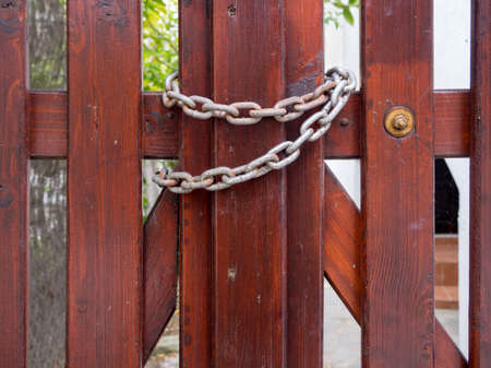 Wooden gate closed and secured with a chainの写真素材