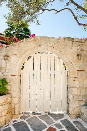 Wooden gate in a stone built wallの写真素材