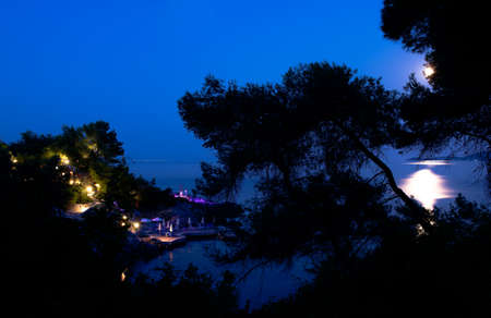 Colourful lights lighting up a small hotel on the seashore.Theの写真素材