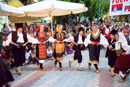 PEFKOHORI , GREECE - SEPTEMBER 19 2014 : Folk Dancers from several countries  taking part in the Annual Folk Dance festival in the village square of Pefkohori ,Greeceのeditorial素材