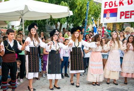 PEFKOHORI , GREECE - SEPTEMBER 19 2014 : Folk Dancers from several countries  taking part in the Annual Folk Dance festival in the village square of Pefkohori ,Greeceのeditorial素材