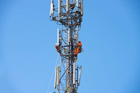WORCESTER,UK - APRIL 14 2015 : Maintenance workers carry out repairs high up on a communications tower using saftey equipmentのeditorial素材