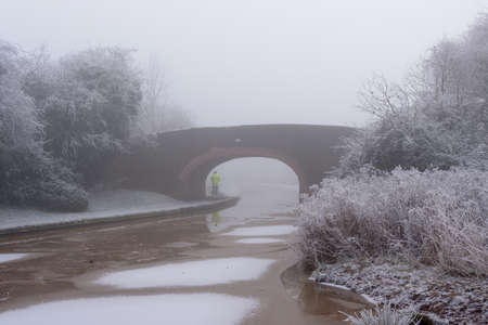 Canal Bridge covered in frost on a cold and foggy Winters dayの写真素材