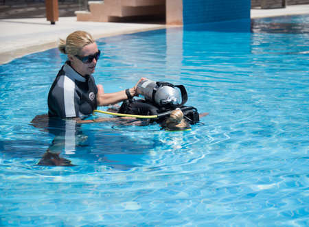 Paliouri,Greece - June 15 2016: Young  woman tries a scuba dive in a pool with an instructor.Scuba diving is a fun sport enjoyed by many people.のeditorial素材