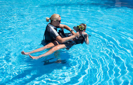 Paliouri,Greece - June 15 2016: Young  woman tries a scuba dive in a pool with an instructor.Scuba diving is a fun sport enjoyed by many people.のeditorial素材