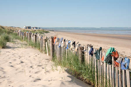 Fence by the sea covered with lost gloves in the town of Greatness,Kent,UK.の写真素材