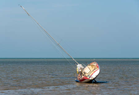 Sailing boat at low tide resting on its sideの写真素材