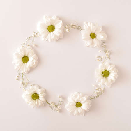 White flowers arranged in a circle on a white background. Spring wedding engagement concept. Flat lay frame.の写真素材