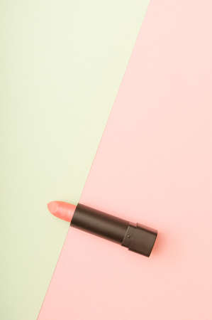 Pink lipstick in a combination of pastel pink and green background. Makeup cosmetic beauty care concept. Flat lay photography with copy space.の写真素材