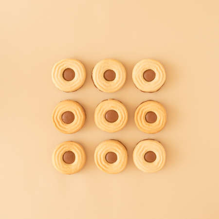 Chocolate cookies arranged in a cube on a cream background. Sweet food biscuit cookie conceptの写真素材