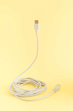 Computer cable for connection on a yellow background. The concept of technology and communication. Minimal compositionの写真素材