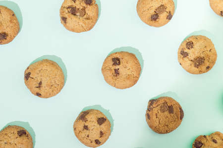 Chocolate chip cookies arranged in a pattern on a turquoise  background. Sweet food concept.の写真素材
