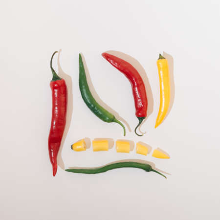 Hot peppers vegetables in several colors arranged in a square shape on a white background. Food conceptの写真素材