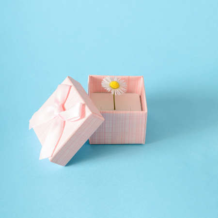 Flower placed in a ring box. A natural idea for a proposal. A creative replacement for jewelry. Blue backgroundの写真素材