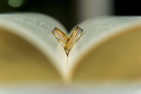 Wedding rings on a open holy bible "BÃ­blia Sagrada". Concept of union, love,...
