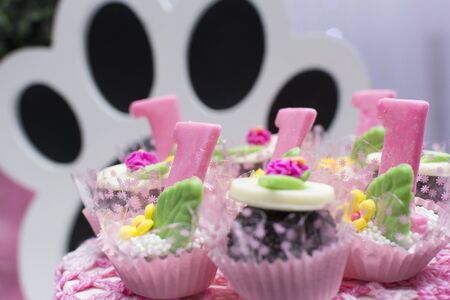 Beautiful candy in number one format. Chocolate confetti Sweets, cakes and girl birthday party decoration details. Selective focus.の写真素材