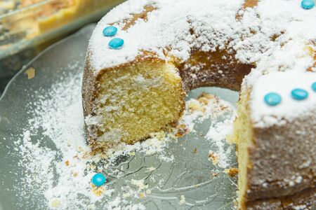 Close up of round delicious cake decorated with icing sugar lies. A festive round cake sprinkled...