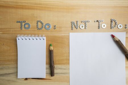 Top view of the phrases to do and not to do made of nuts and washers on a wooden surface for...