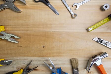 A high angle shot of many working instruments on a light wooden surface. construction tools on wooden background shot from above. Top view, flat lay. Construction, repair, production and DIY concept.の写真素材