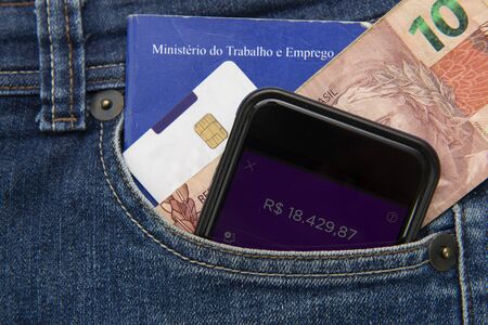 Close up of cell phone in pocket of pants with positive bank balance. Portfolio of work and social...