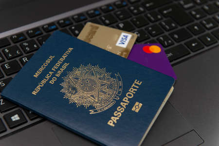 Florianopolis, Brazil. June 27, 2020: Close up Brazilian passport with credit cards inside on laptop...