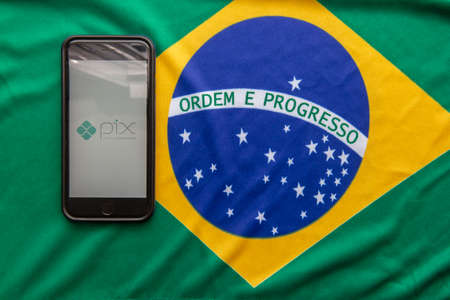 Florianopolis, Brazil. 09/28/2020: Top view of Pix logo on smartphone screensabout the Brazilian flag. Pix, new Brazilian electronic payment system. Brazilian Central Bank. Copy space.のeditorial素材