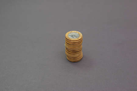 Stack of 1 real coins isolated on black background. Concept of saving money and small, medium and...
