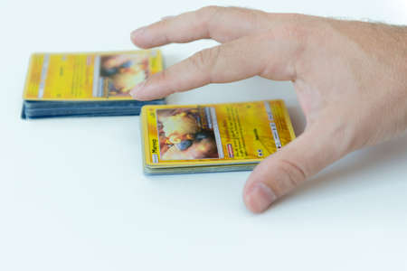 Florianopolis, Brazil, July 13, 2019: close-up of a man hand holding Pokemon Cards. Brazilian youths perform battles using these collectibles cards.のeditorial素材